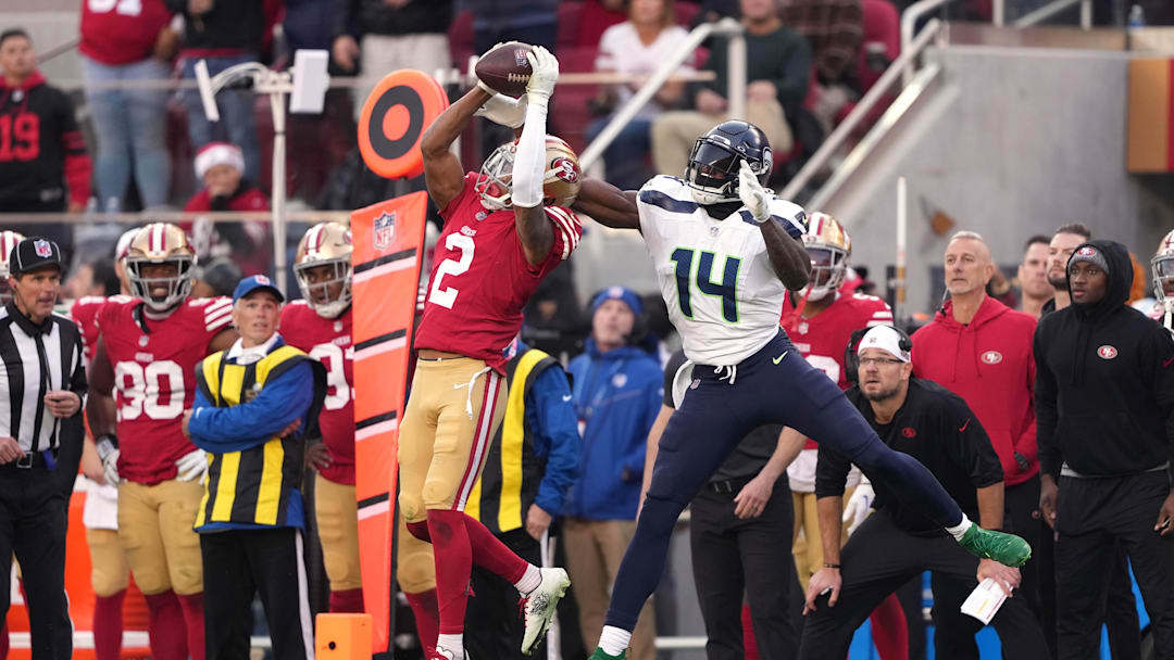 Dec 10, 2023; Santa Clara, California, USA; San Francisco 49ers cornerback Deommodore Lenoir (2) intercepts a pass intended for Seattle Seahawks wide receiver DK Metcalf (14) during the fourth quarter at Levi's Stadium. The play was nullified by a penalty.  Mandatory Credit: Darren Yamashita-Imagn Images