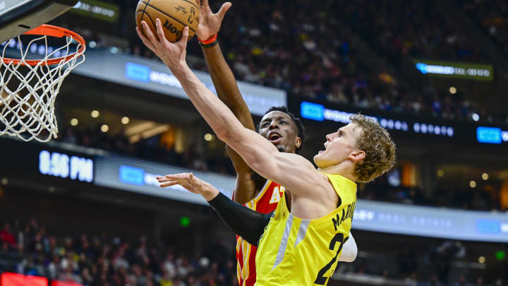 Feb 3, 2023; Salt Lake City, Utah, USA; Utah Jazz forward/center Lauri Markkanen (23) takes a layup around Atlanta Hawks forward/center Onyeka Okongwu (17) during the second half at Vivint Arena. Mandatory Credit: Christopher Creveling-USA TODAY Sports