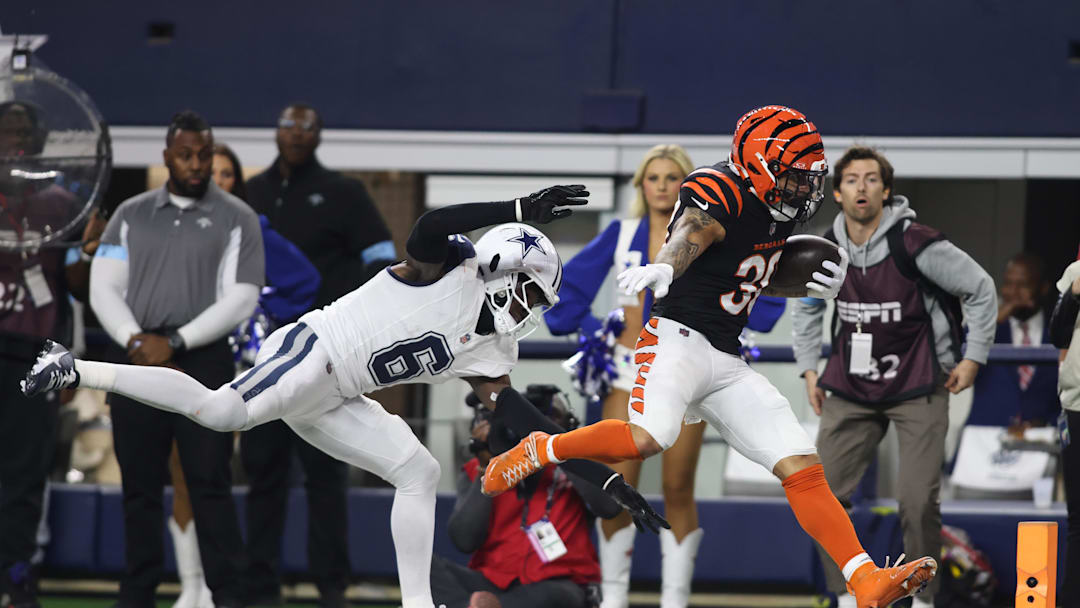 Dec 9, 2024; Arlington, Texas, USA; Cincinnati Bengals cornerback DJ Turner II (20) scores a touchdown against Dallas Cowboys safety Donovan Wilson (6) in the second quarter at AT&T Stadium. Mandatory Credit: Tim Heitman-Imagn Images