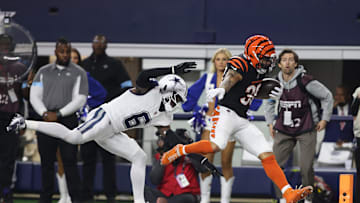 Dec 9, 2024; Arlington, Texas, USA; Cincinnati Bengals cornerback DJ Turner II (20) scores a touchdown against Dallas Cowboys safety Donovan Wilson (6) in the second quarter at AT&T Stadium. Mandatory Credit: Tim Heitman-Imagn Images