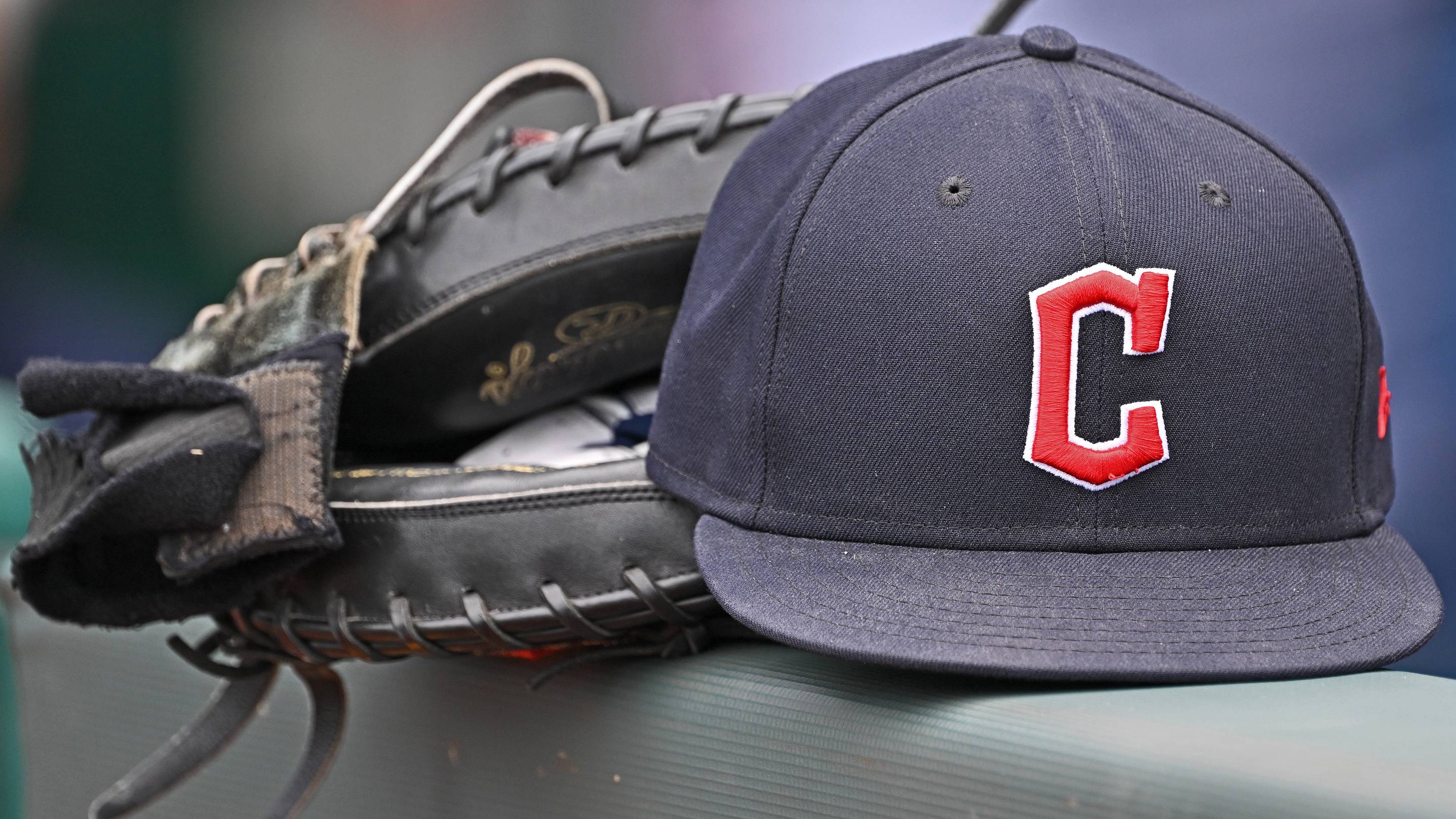Jun 27, 2024; Kansas City, Missouri, USA; A general view a Cleveland Guardians hat and glove on the dugout railing before a game against the Kansas City Royals at Kauffman Stadium.