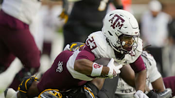 Nov 8, 2025; Columbia, Missouri, USA; Texas A&M Aggies running back Jamarion Morrow (23) dives forward against Missouri Tigers linebacker Triston Newson (14) during the first half at Faurot Field at Memorial Stadium. Mandatory Credit: Jay Biggerstaff-Imagn Images