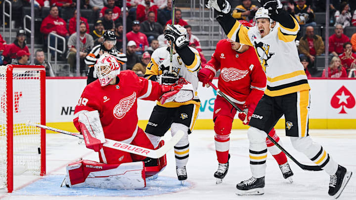 Oct 10, 2024; Detroit, Michigan, USA; Pittsburgh Penguins right wing Rickard Rakell (67) and center Sidney Crosby (87) celebrate the goal of defenseman Erik Karlsson (not pictured) as Detroit Red Wings goaltender Cam Talbot (39) tends the net during the third period at Little Caesars Arena. Mandatory Credit: Tim Fuller-Imagn Images