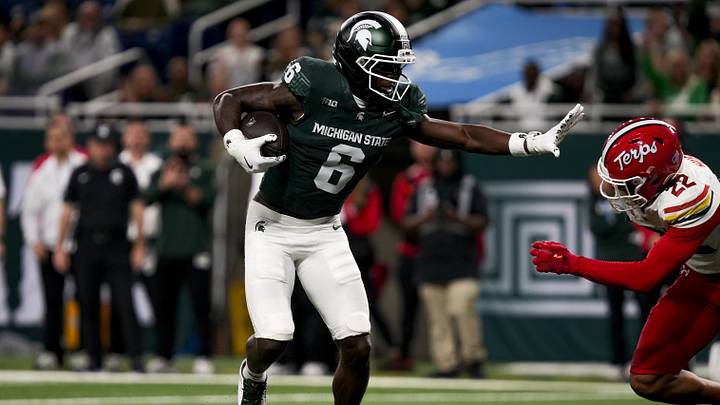 Nov 29, 2025; Detroit, Michigan, USA; Michigan State wide receiver Nick Marsh (6) stiff arms Maryland defensive back Jalen Huskey (22) in the second quarter at Ford Field. Mandatory Credit: Brendan Mullin-Imagn Images