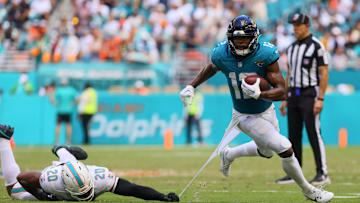 Sep 8, 2024; Miami Gardens, Florida, USA; Jacksonville Jaguars wide receiver Devin Duvernay (12) runs with the football past Miami Dolphins linebacker Jordyn Brooks (20) during the third quarter at Hard Rock Stadium. Mandatory Credit: Sam Navarro-Imagn Images