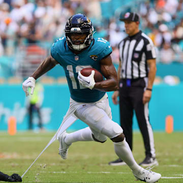 Sep 8, 2024; Miami Gardens, Florida, USA; Jacksonville Jaguars wide receiver Devin Duvernay (12) runs with the football past Miami Dolphins linebacker Jordyn Brooks (20) during the third quarter at Hard Rock Stadium. Mandatory Credit: Sam Navarro-Imagn Images