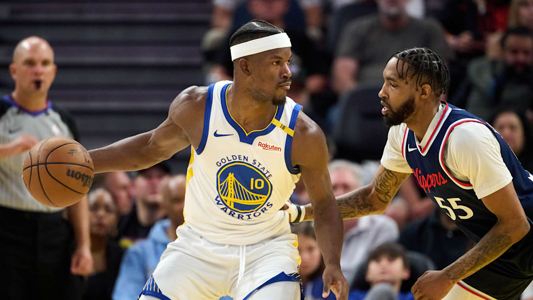 Apr 13, 2025; San Francisco, California, USA; Golden State Warriors forward Jimmy Butler III (10) dribbles the ball against LA Clippers forward Derrick Jones Jr. (55) as referee Jacyn Goble (68) watches the play during the fourth quarter at Chase Center. Mandatory Credit: Robert Edwards-Imagn Images