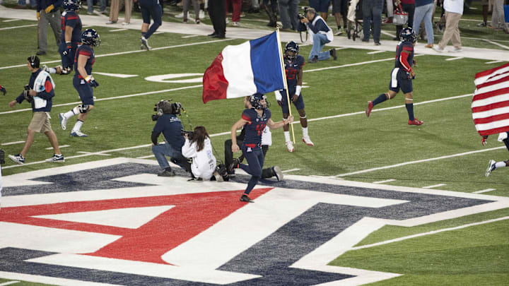 Nov 14, 2015; Tucson, AZ, USA; Arizona Wildcats place kicker Casey Skowron (41) runs onto the field with the French flag before the game against the Utah Utes at Arizona Stadium. Mandatory Credit: Casey Sapio-Imagn Images