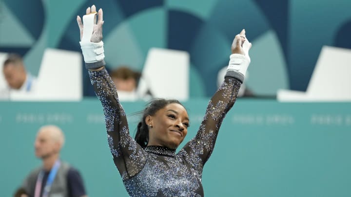 Jul 28, 2024; Paris, France; Simone Biles of the United States performs on the uneven bars in women's qualification during the Paris 2024 Olympic Summer Games at Bercy Arena. 