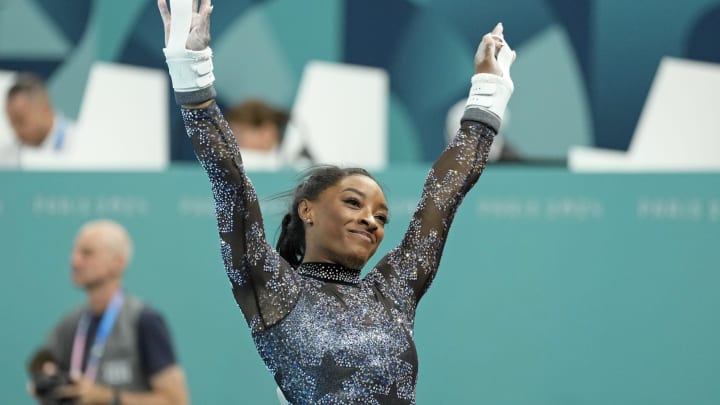 Jul 28, 2024; Paris, France; Simone Biles of the United States performs on the uneven bars in women's qualification during the Paris 2024 Olympic Summer Games at Bercy Arena.