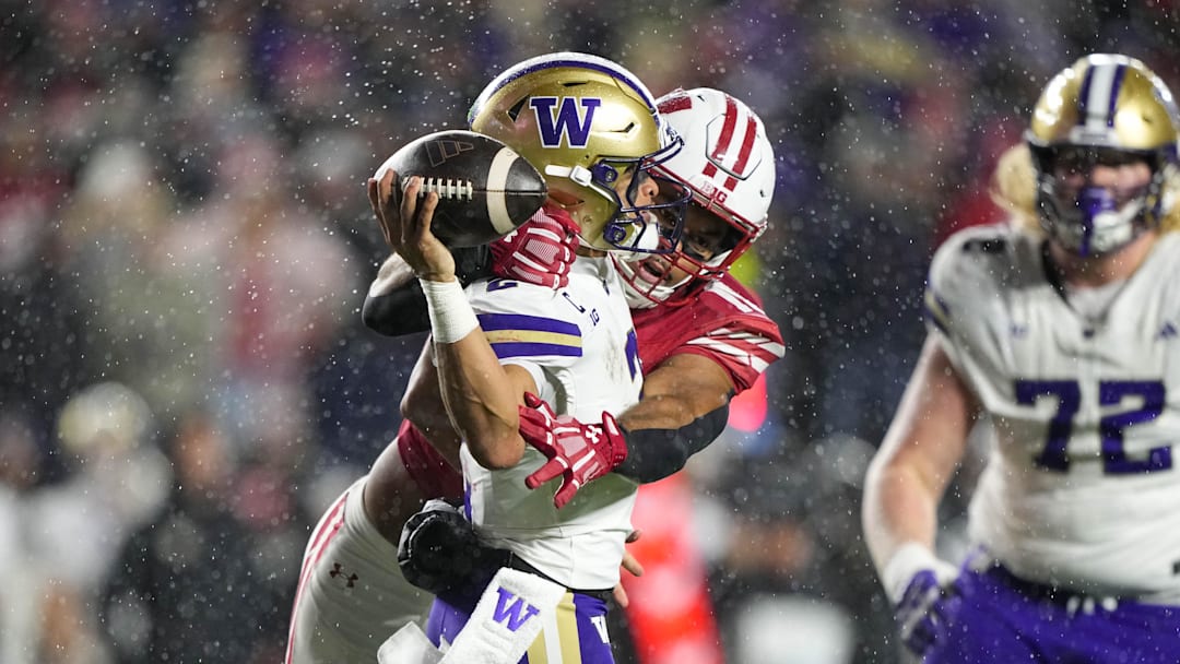 Nov 8, 2025; Madison, Wisconsin, USA;  Washington Huskies quarterback Demond Williams Jr. (2) throws the football away under pressure from Wisconsin Badgers linebacker Sebastian Cheeks (15) during the third quarter at Camp Randall Stadium. Mandatory Credit: Jeff Hanisch-Imagn Images