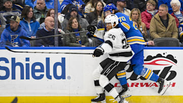 Mar 1, 2025; St. Louis, Missouri, USA;  Los Angeles Kings center Akil Thomas (26) checks St. Louis Blues center Oskar Sundqvist (70) during the first period at Enterprise Center. Mandatory Credit: Jeff Curry-Imagn Images