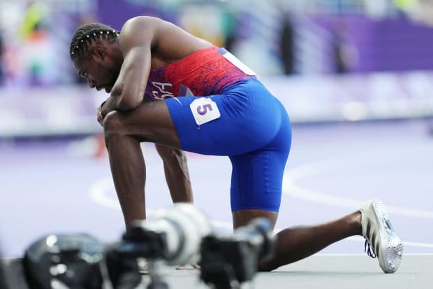 Noah Lyles takes a knee after running the Olympics.