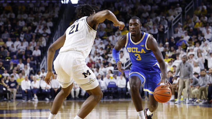 Feb 14, 2026; Ann Arbor, Michigan, USA; UCLA Bruins guard Eric Dailey Jr. (3) dribbles defended by Michigan Wolverines forward Morez Johnson Jr. (21) in the second half at Crisler Center. Mandatory Credit: Rick Osentoski-Imagn Images