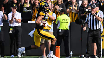 Oct 12, 2024; Iowa City, Iowa, USA; Iowa Hawkeyes defensive back John Nestor (7) scores on a touchdown pass from quarterback Cade McNamara (12) during the fourth quarter against the Washington Huskies at Kinnick Stadium. Mandatory Credit: Jeffrey Becker-Imagn Images