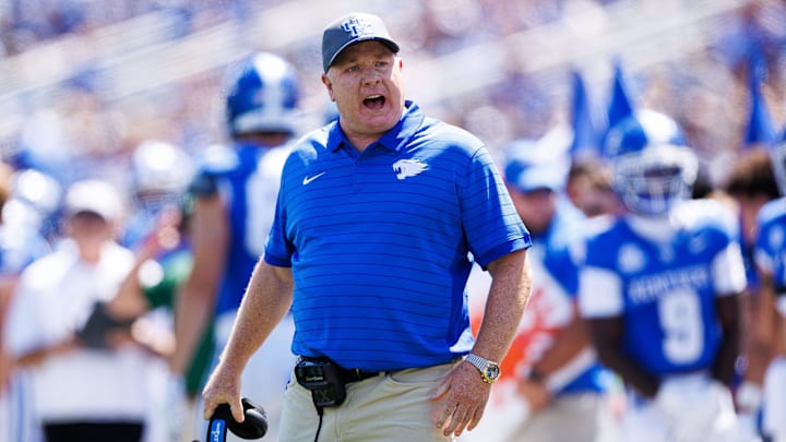 Aug 30, 2025; Lexington, Kentucky, USA; Kentucky Wildcats head coach Mark Stoops discusses a play with a referee during the first quarter against the Toledo Rockets at Kroger Field. Mandatory Credit: Jordan Prather-Imagn Images