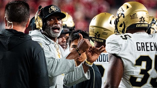 Colorado Buffaloes head coach Deion Sanders talks with players during a timeout 