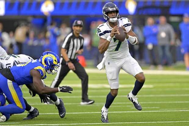 Seattle Seahawks quarterback Geno Smith scrambles away from a Los Angeles Rams linebacker and throws for a touchdown.