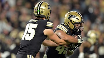 Purdue Boilermakers quarterback Ryan Browne (15) hands off the ball to running back Devin Mockobee (45)