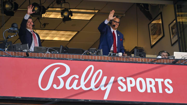 Bally Sports Midwest announcer Chip Caray and Brad Thompson wave to the fans during the second inning of an opening day game between the St. Louis Cardinals and the Toronto Blue Jays at Busch Stadium. 