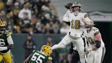 New Orleans Saints quarterback Spencer Rattler (18) is pressured by Green Bay Packers defensive end Kingsley Enagbare (55) during the third quarter of their game Monday, December 23, 2024 at Lambeau Field in Green Bay, Wisconsin.