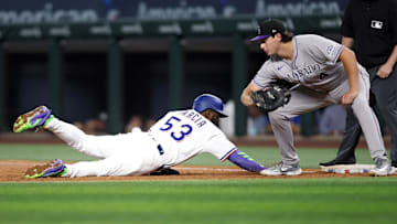 May 14, 2025; Arlington, Texas, USA; Texas Rangers outfielder Adolis García (53) dives back to first base as Colorado Rockies first base Michael Toglia (4) attempts to make the tag during the third inning at Globe Life Field. Mandatory Credit: Tim Heitman-Imagn Images