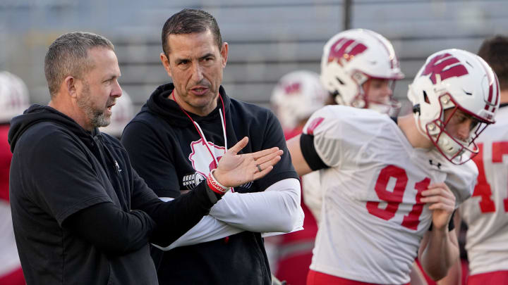 Wisconsin outside linebackers coach Matt Mitchell, left, talks with head coach Luke Fickell during practice April 11 at Camp Randall Stadium in Madison