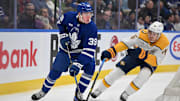 Dec 4, 2024; Toronto, Ontario, CAN;  Toronto Maple Leafs forward Fraser Minten (39) controls the puck against Nashville Predators defenseman Brady Skjei (76) in the first period at Scotiabank Arena. Mandatory Credit: Dan Hamilton-Imagn Images
