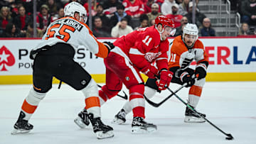 Dec 18, 2024; Detroit, Michigan, USA; Detroit Red Wings right wing Vladimir Tarasenko (11) battles for the puck abasing Philadelphia Flyers defenseman Rasmus Ristolainen (55) and right wing Travis Konecny (11) during the second period at Little Caesars Arena. Mandatory Credit: Tim Fuller-Imagn Images