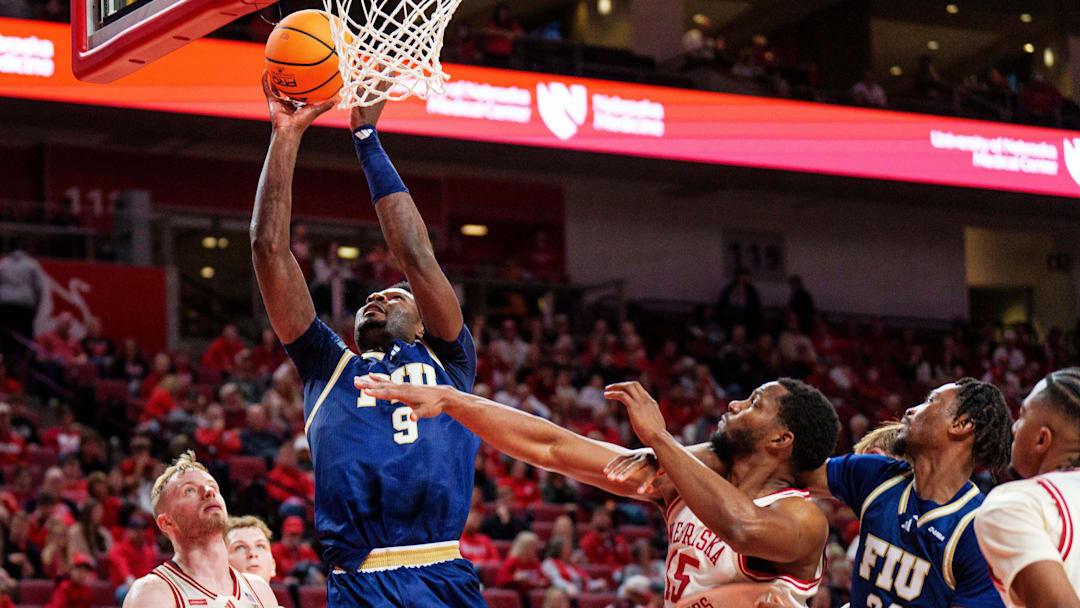 Nov 8, 2025; Lincoln, Nebraska, USA; Florida International Panthers forward Eric Dibami (9) shoots the ball against Nebraska Cornhuskers forward Rienk Mast (51) and forward Jared Garcia (15) during the second half at Pinnacle Bank Arena. Mandatory Credit: Dylan Widger-Imagn Images