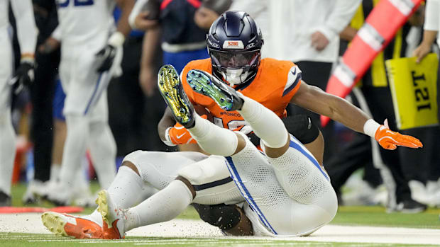 Indianapolis Colts safety Nick Cross (20) brings down Denver Broncos running back RJ Harvey (12) at Lucas Oil Stadium. 