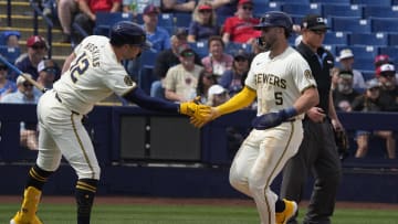 Mar 18, 2024; Phoenix, Arizona, USA; Milwaukee Brewers center fielder Garrett Mitchell (5) celebrates with first baseman Rhys Hoskins (12) after scoring against the Los Angeles Angels in the first inning at American Family Fields of Phoenix. Mandatory Credit: Rick Scuteri-USA TODAY Sports