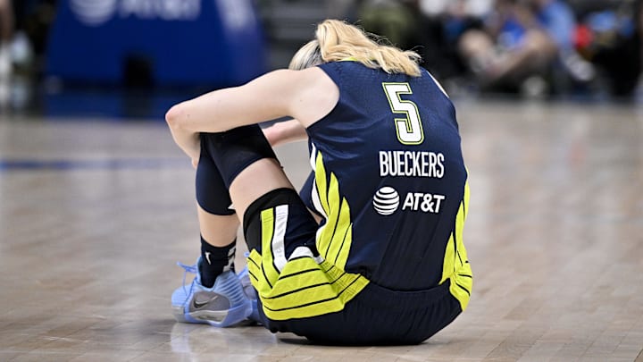 Aug 1, 2025; Dallas, Texas, USA; Dallas Wings guard Paige Bueckers (5) sits on the court floor after suffering an apparent leg injury during the second half against the Indiana Fever at the American Airlines Center. Mandatory Credit: Jerome Miron-Imagn Images Aug 1, 2025; Dallas, Texas, USA; Dallas Wings guard Paige Bueckers (5) sits on the court floor after suffering an apparent leg injury during the second half against the Indiana Fever at the American Airlines Center. Mandatory Credit: Jerome Miron-Imagn Images