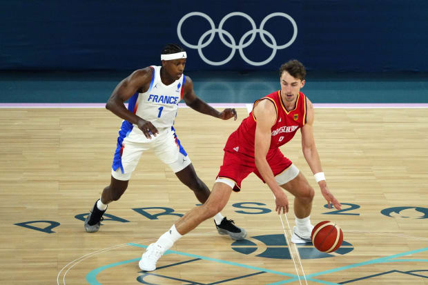 Germany forward Franz Wagner dribbles the ball while defended by France point guard Frank Ntilikina.