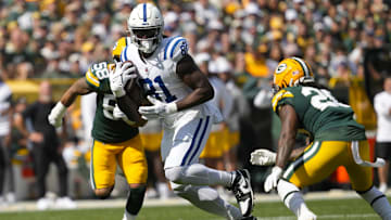 Sep 15, 2024; Green Bay, Wisconsin, USA;  Indianapolis Colts tight end Mo Alie-Cox (81) rushes with the football between Green Bay Packers linebacker Isaiah McDuffie (58) and safety Javon Bullard (20) during the third quarter at Lambeau Field. Mandatory Credit: Jeff Hanisch-Imagn Images
