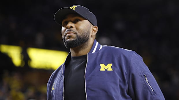 Michigan Wolverines head football coach Sherrone Moore fires up the crowd in overtime of the basketball game
