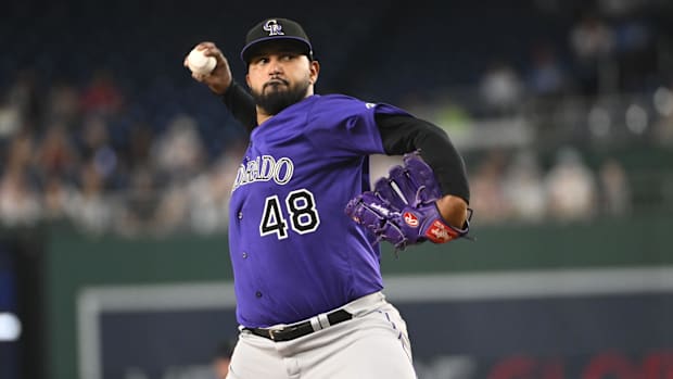 Colorado Rockies starting pitcher German Marquez throws while wearing a purple jersey and black hat