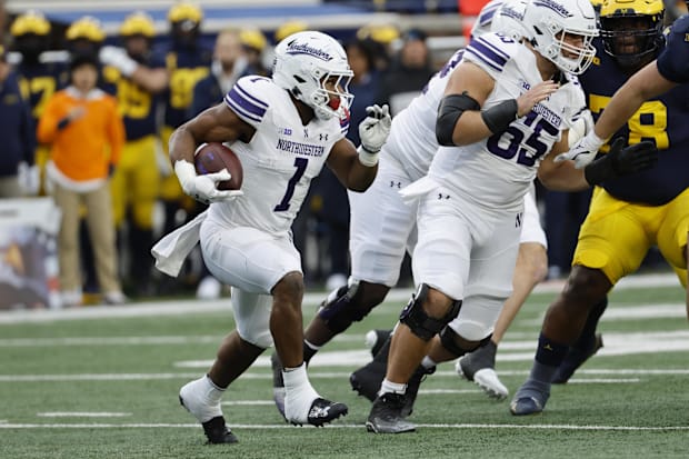 Northwestern Wildcats running back Cam Porter (1) runs the ball against the Michigan Wolverines in the first half at Michigan