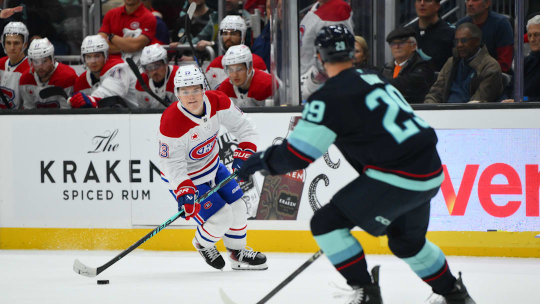 Oct 28, 2025; Seattle, Washington, USA; Montreal Canadiens right wing Cole Caufield (13) plays the puck while defended by Seattle Kraken defenseman Vince Dunn (29) during overtime at Climate Pledge Arena. Mandatory Credit: Steven Bisig-Imagn Images