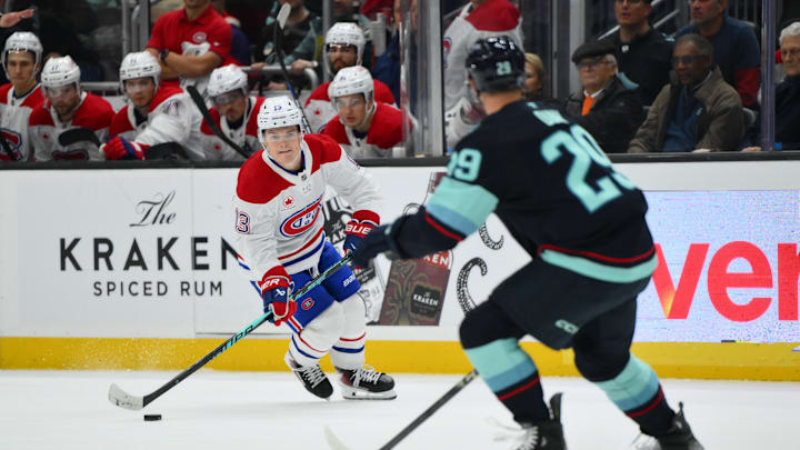 Oct 28, 2025; Seattle, Washington, USA; Montreal Canadiens right wing Cole Caufield (13) plays the puck while defended by Seattle Kraken defenseman Vince Dunn (29) during overtime at Climate Pledge Arena. Mandatory Credit: Steven Bisig-Imagn Images