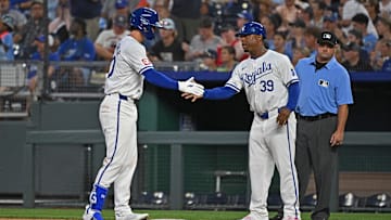 Jul 2, 2024; Kansas City, Missouri, USA;  Kansas City Royals third baseman CJ Alexander (40) get hand from first base coach Damon Hollins (39) after getting his first Major League hit in the fifth inning against the Tampa Bay Rays at Kauffman Stadium. Mandatory Credit: Peter Aiken-Imagn Images