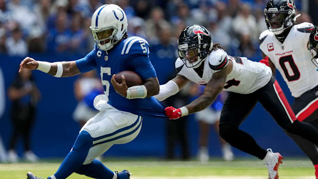 Colts quarterback Anthony Richardson (blue jersey; white helmet) slides to avoid contact after a run. 