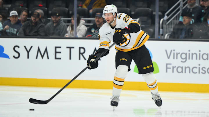 Jan 6, 2026; Seattle, Washington, USA; Boston Bruins defenseman Andrew Peeke (26) passes the puck against the Seattle Kraken during the second period at Climate Pledge Arena. Mandatory Credit: Steven Bisig-Imagn Images