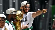 Jun 21, 2024; Boston, MA, USA; Boston Celtics forward Jayson Tatum (0) points to the crowd with the Larry O'Brien Championship Trophy during the 2024 NBA Championship parade in Boston. Mandatory Credit: Brian Fluharty-USA TODAY Sports