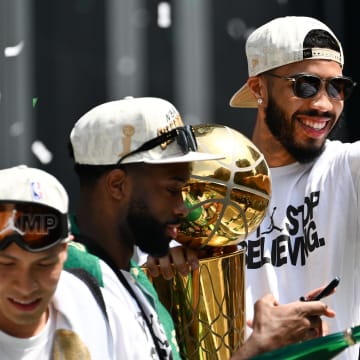 Jun 21, 2024; Boston, MA, USA; Boston Celtics forward Jayson Tatum (0) points to the crowd with the Larry O'Brien Championship Trophy during the 2024 NBA Championship parade in Boston. Mandatory Credit: Brian Fluharty-USA TODAY Sports