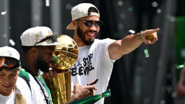 Jun 21, 2024; Boston, MA, USA; Boston Celtics forward Jayson Tatum (0) points to the crowd with the Larry O'Brien Championship Trophy during the 2024 NBA Championship parade in Boston. Mandatory Credit: Brian Fluharty-USA TODAY Sports