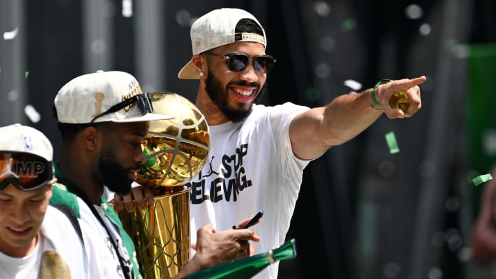 Jun 21, 2024; Boston, MA, USA; Boston Celtics forward Jayson Tatum (0) points to the crowd with the Larry O'Brien Championship Trophy during the 2024 NBA Championship parade in Boston. Mandatory Credit: Brian Fluharty-USA TODAY Sports