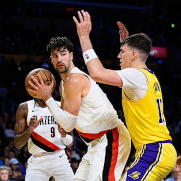Oct 27, 2025; Los Angeles, California, USA; Portland Trail Blazers forward Deni Avdija (8) looks to pass while under pressure from Los Angeles Lakers forward Jake LaRavia (12) during the first half at Crypto.com Arena. Mandatory Credit: William Liang-Imagn Images