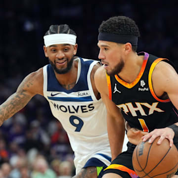 Apr 28, 2024; Phoenix, Arizona, USA; Minnesota Timberwolves guard Nickeil Alexander-Walker (9) guards Phoenix Suns guard Devin Booker (1) during the second half of game four of the first round for the 2024 NBA playoffs at Footprint Center. Mandatory Credit: Joe Camporeale-Imagn Images