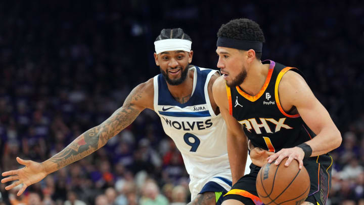 Apr 28, 2024; Phoenix, Arizona, USA; Minnesota Timberwolves guard Nickeil Alexander-Walker (9) guards Phoenix Suns guard Devin Booker (1) during the second half of game four of the first round for the 2024 NBA playoffs at Footprint Center. Mandatory Credit: Joe Camporeale-USA TODAY Sports